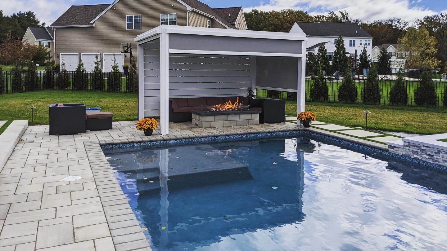 A sitting area near a swimming pool outside a house